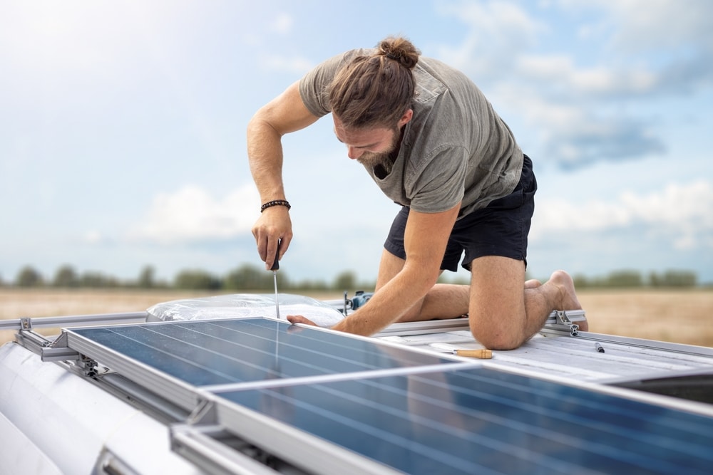 Person,Working,On,Solar,Panels,On,Top,Of,A,Van